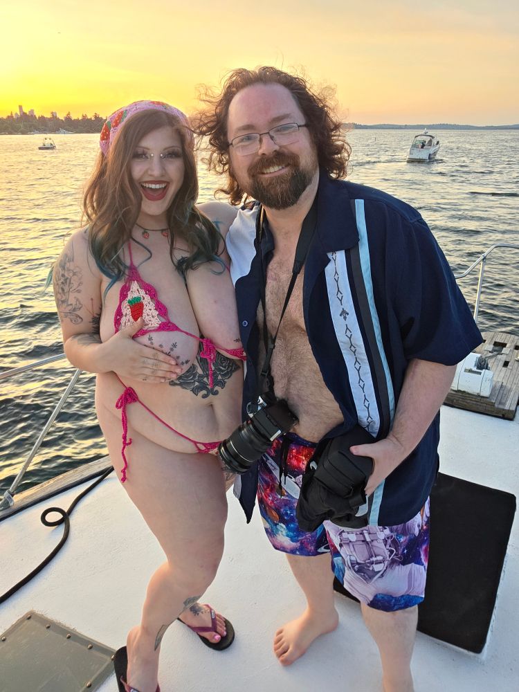 Mistress of Magik and Nathaniel stand on the bow of the ship as the sun sets over the water