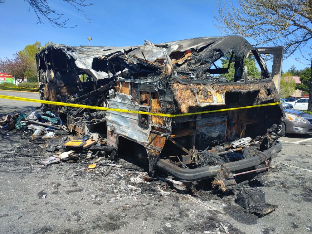 The burned out remains of an RV in a parking lot in Olympia