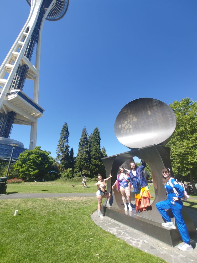 Friends standing in a piece of art in front of the Seattle Space Needle, including me this time