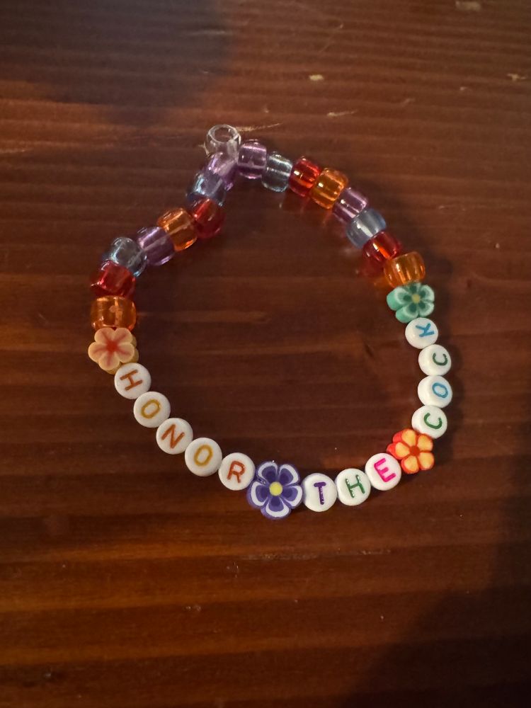 Friendship bracelet that says "Honor the cock" in an ode to Brian Murphy 