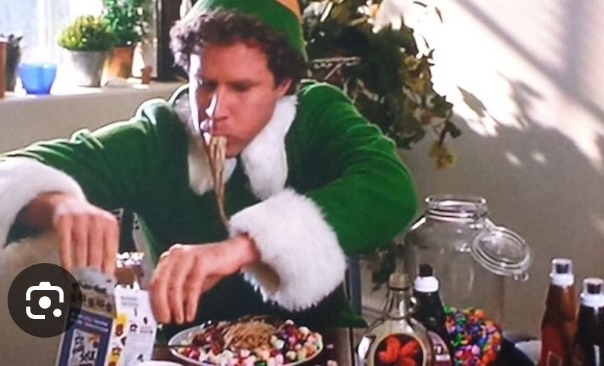 Elf eating candy and spaghetti like he's been starving for days