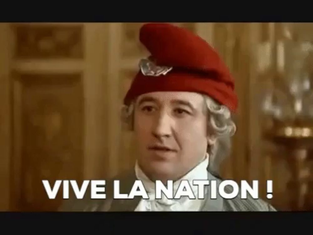 a man wearing a red hat and wig is saying vive la nation !