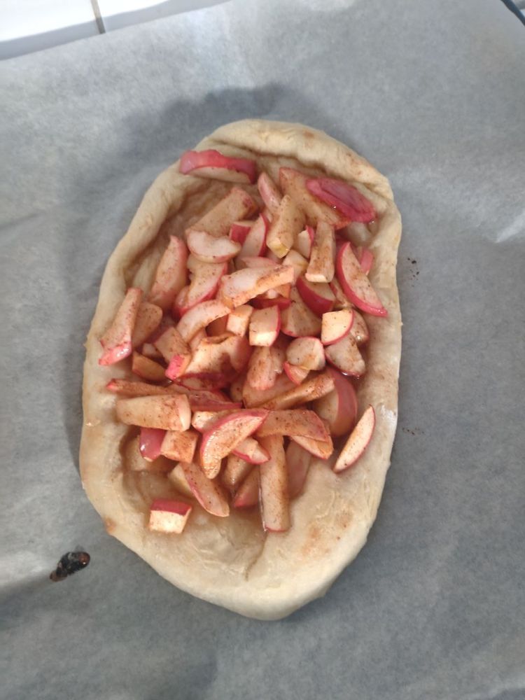 pizza em formato de elipse com maçãs