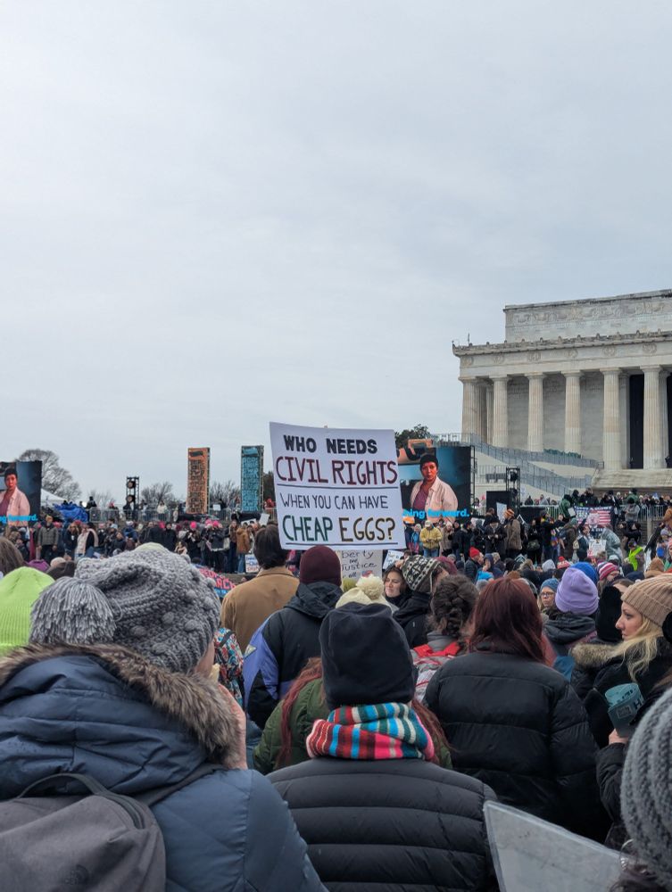 A protester near the Lincoln memorial holds up a sign that reads "Who needs civil rights when you can have cheap eggs?"