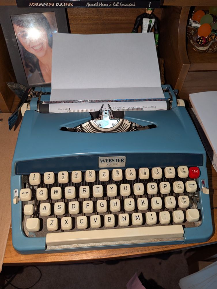 A blue 1967 Webster XL-500 typewriter sitting on a desk