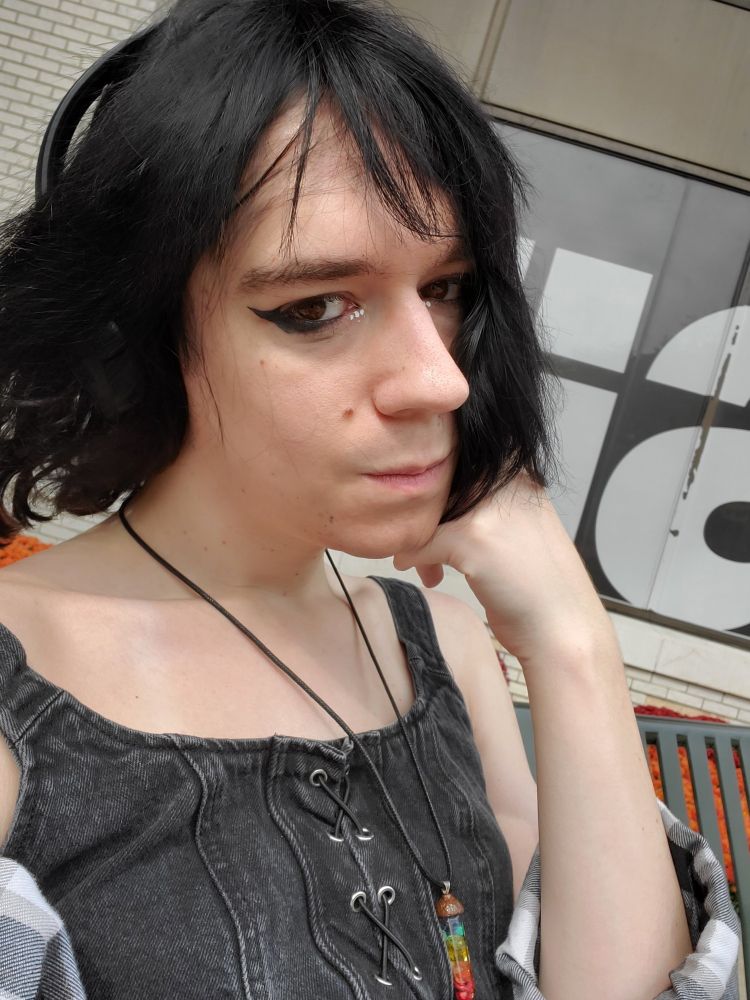 me in a black corset type top and a lip rainbow necklace thingy and some cute makeup :3 it's vvv bright out and it's hard for me to keep my eyes open it's so tragic