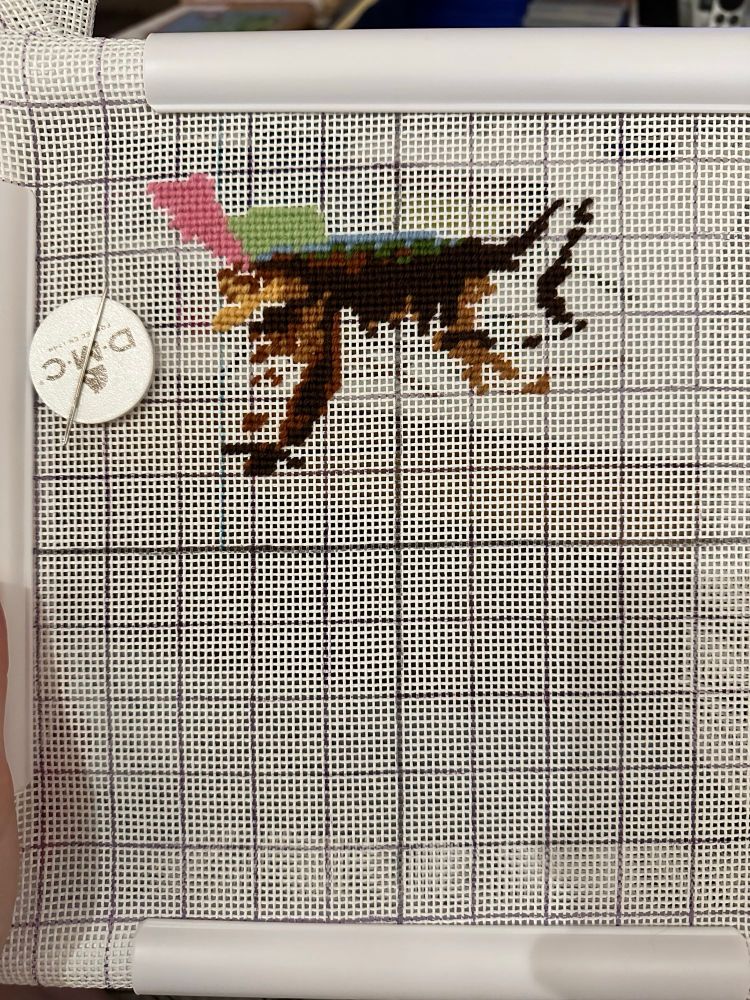 A needlepoint canvas with a few scattered stitches on it