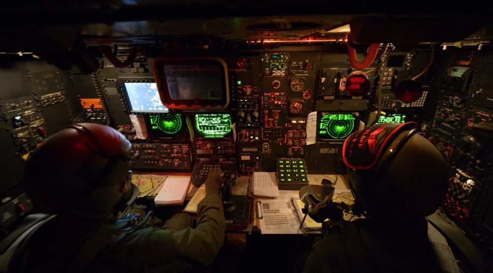 The battle station of a B-52 bomber with glowing green screens and numerous backlit buttons and switches