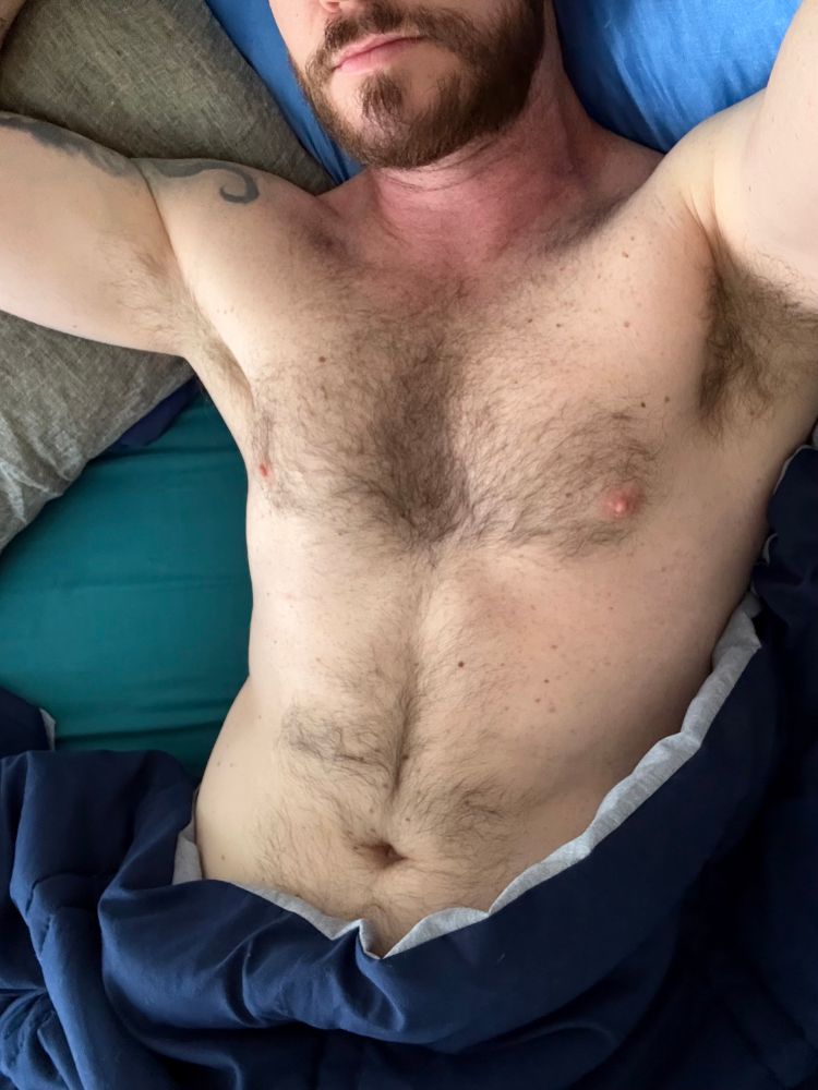 my torso in bed with blankets and pillows surrounding it 