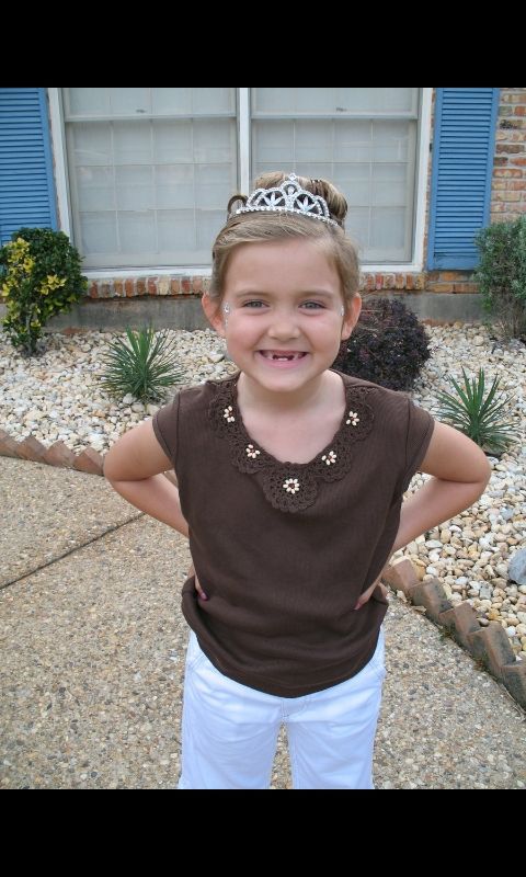 baby t wearing a tiara and a big smile with no front teeth 