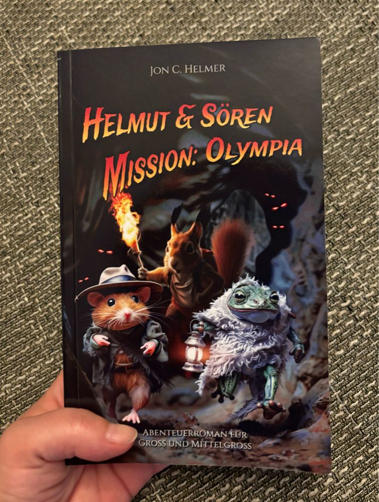Ich halte das Buch „Helmut & Sören - Mission: Olympia“ von Jon C. Helmer in der Hand.