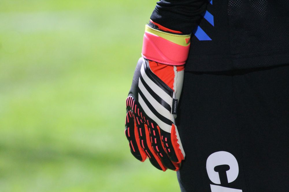 A closeup of her mostly red goalkeeper glove, which had some black and some white on it