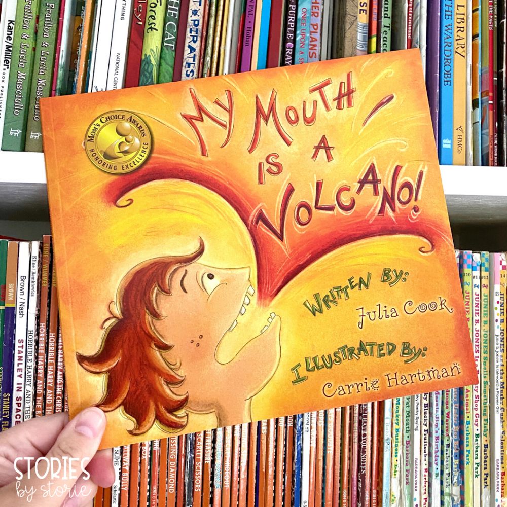 Hand holding a children's book called My Mouth Is A Volcano, bu Julia Cook.