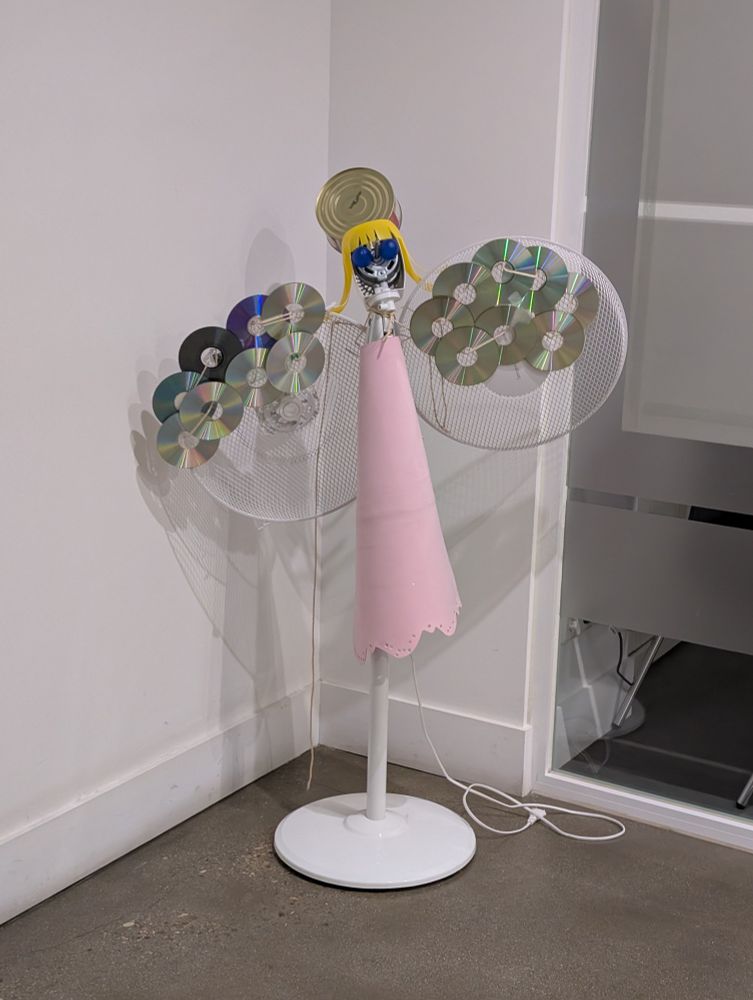 Decoración navideña con forma de ángel realizada con materiales reutilizados como CDs usados, una lata de atún o un ventilador viejo.
