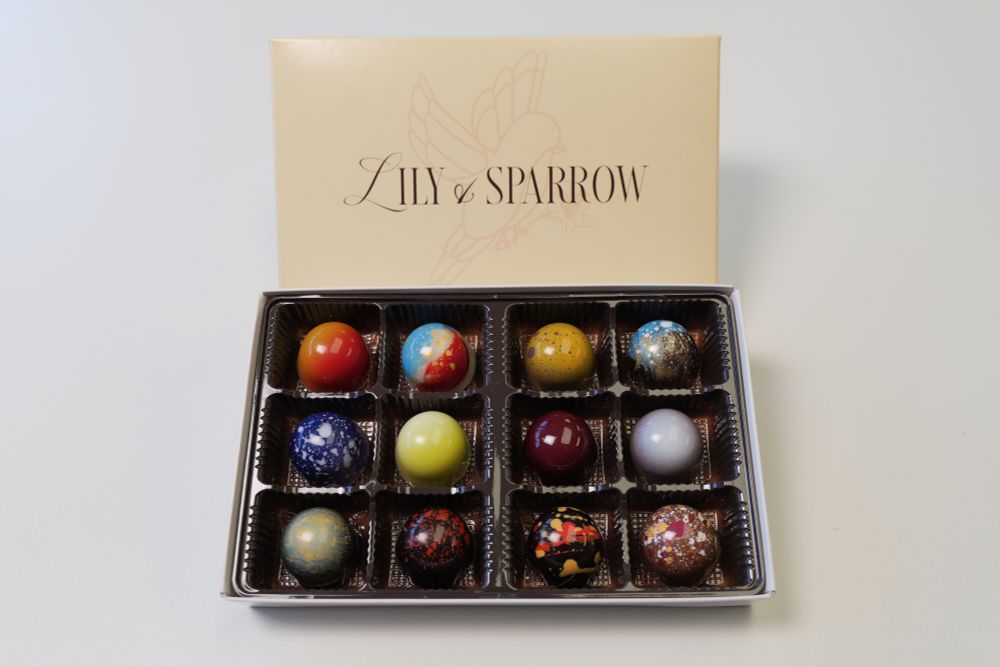12pc chocolate bonbons in a cream box with the "Lily & Sparrow" text with a bird faded behind it.