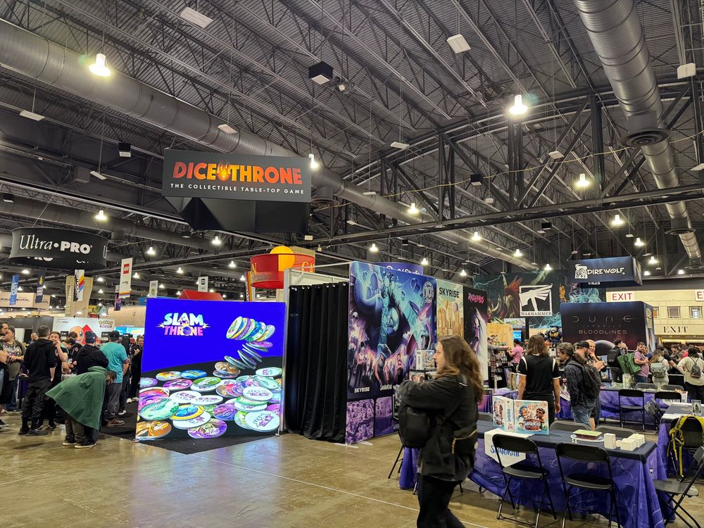 A view of the exhibit hall down the right side showing groups like roxley and direwolf and catan