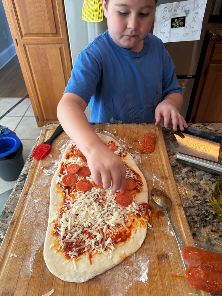 Rolled out dough with sauce cheese and pepperoni 