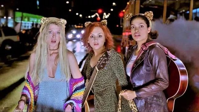 Still from the movie "Josie and the Pussycats" featuring (left to right) Tara Reid, Jennifer Jason Leigh, and Rosario Dawson. 