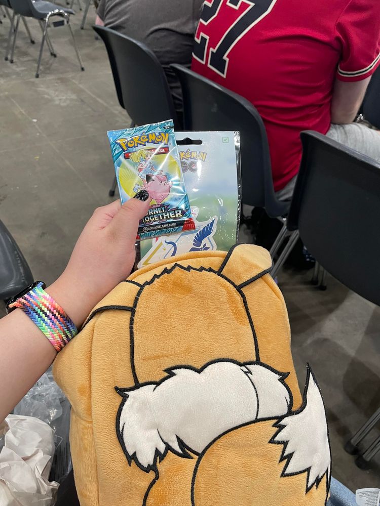 Photo of Eevee backpack and a booster pack (Journey Together) and a sticker pack (Pokémon Go teams)