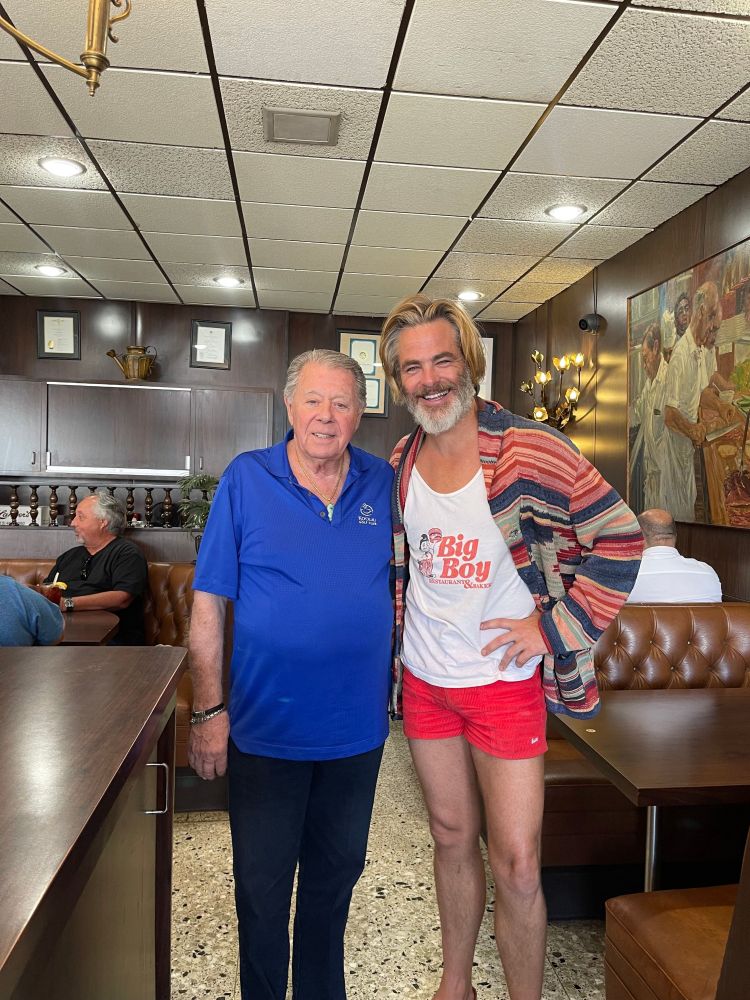Chris Pines in a diner looking unfairly attractive in a Big Boy tank, red Hammies, and a striped chunky knit cardigan. 
