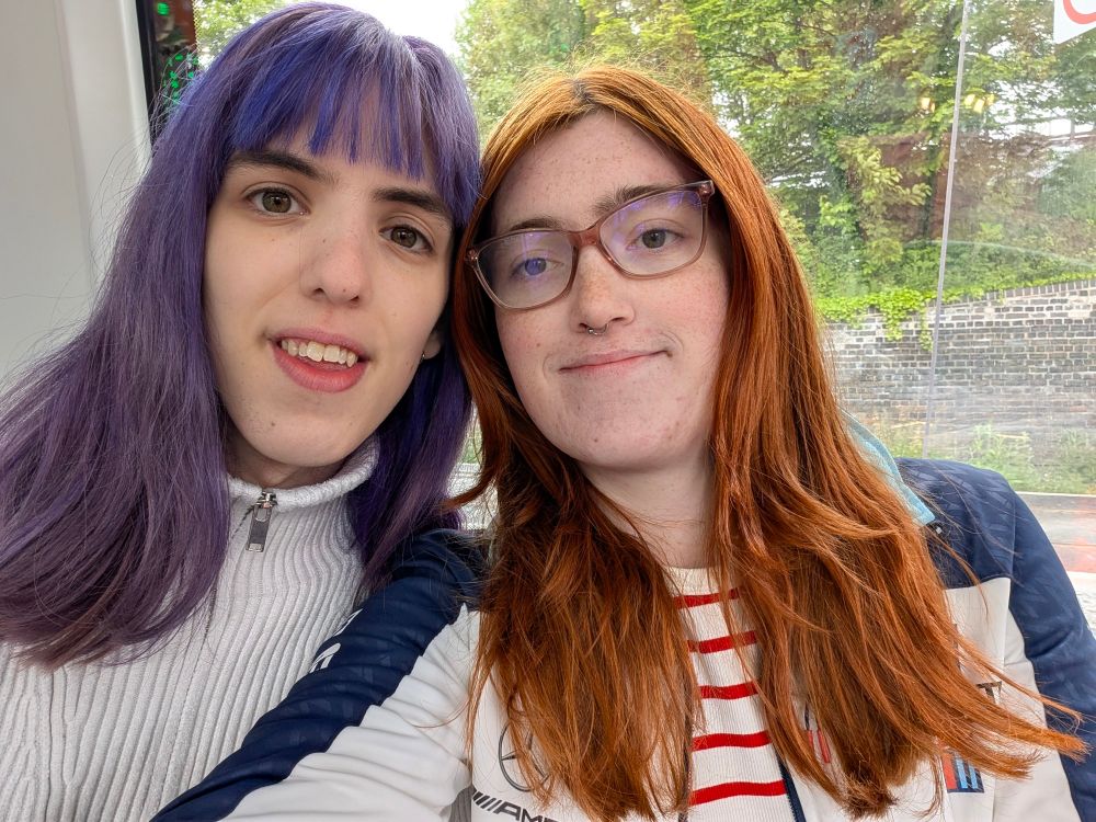 Me and Fiona on the Coventry Very Light Veichle. I have got copper hair wearing a Williams F1 jacket and a white and red crop top. Fiona has purple hair and is in a white jumper.