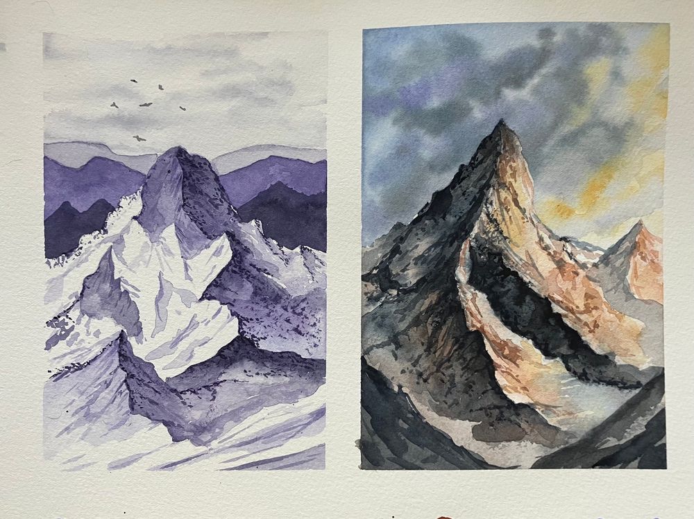 A pair of watercolor landscape paintings of mountains on the same page. The left painting is monochromatic with shades of purple. The right painting has complex areas of dark valley with areas of light illuminated by yellow light in the sky. 