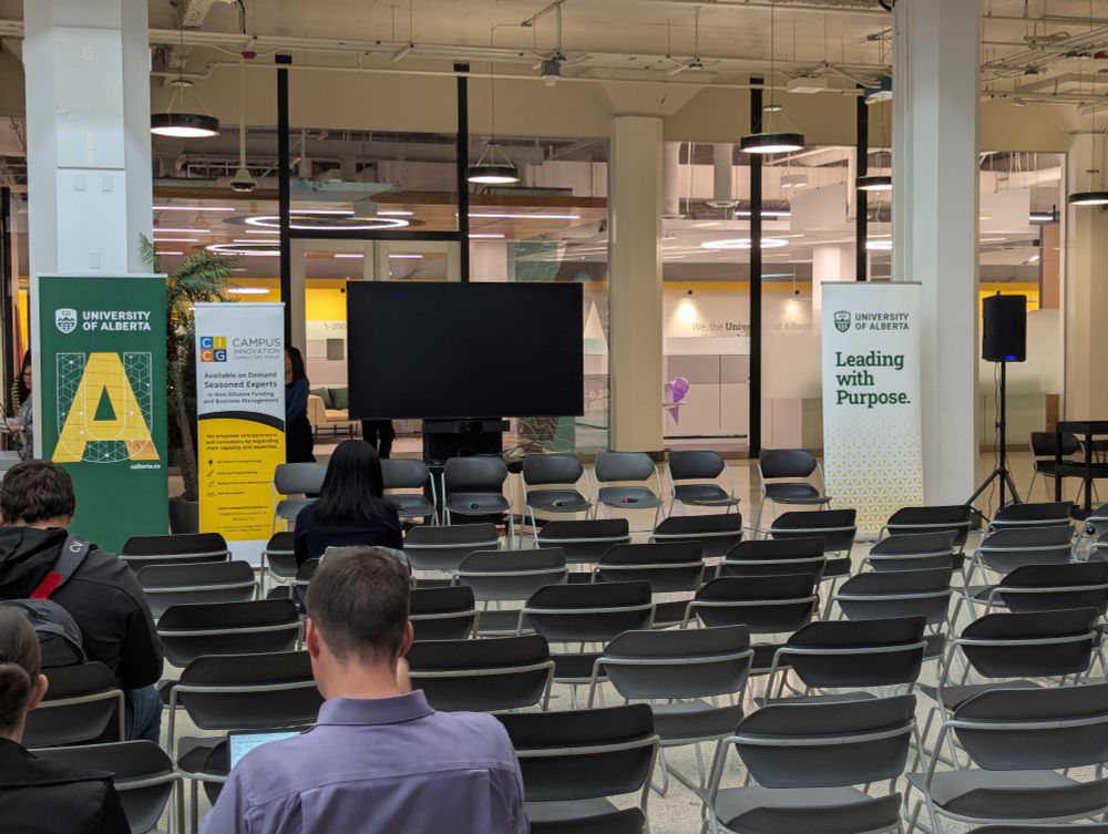 An array of chairs facing a panel set of chairs before an event begins