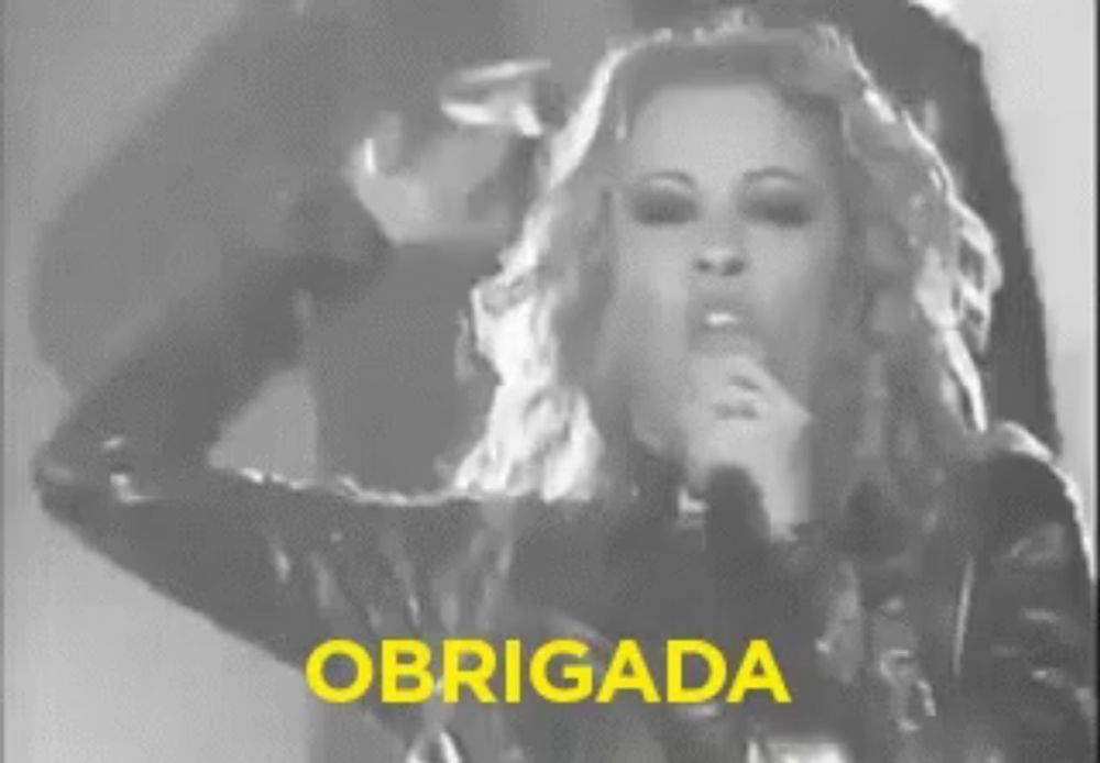 a woman is singing into a microphone with the word obrigada in yellow