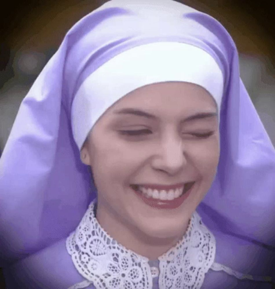 a woman wearing a purple veil and a white head scarf is smiling