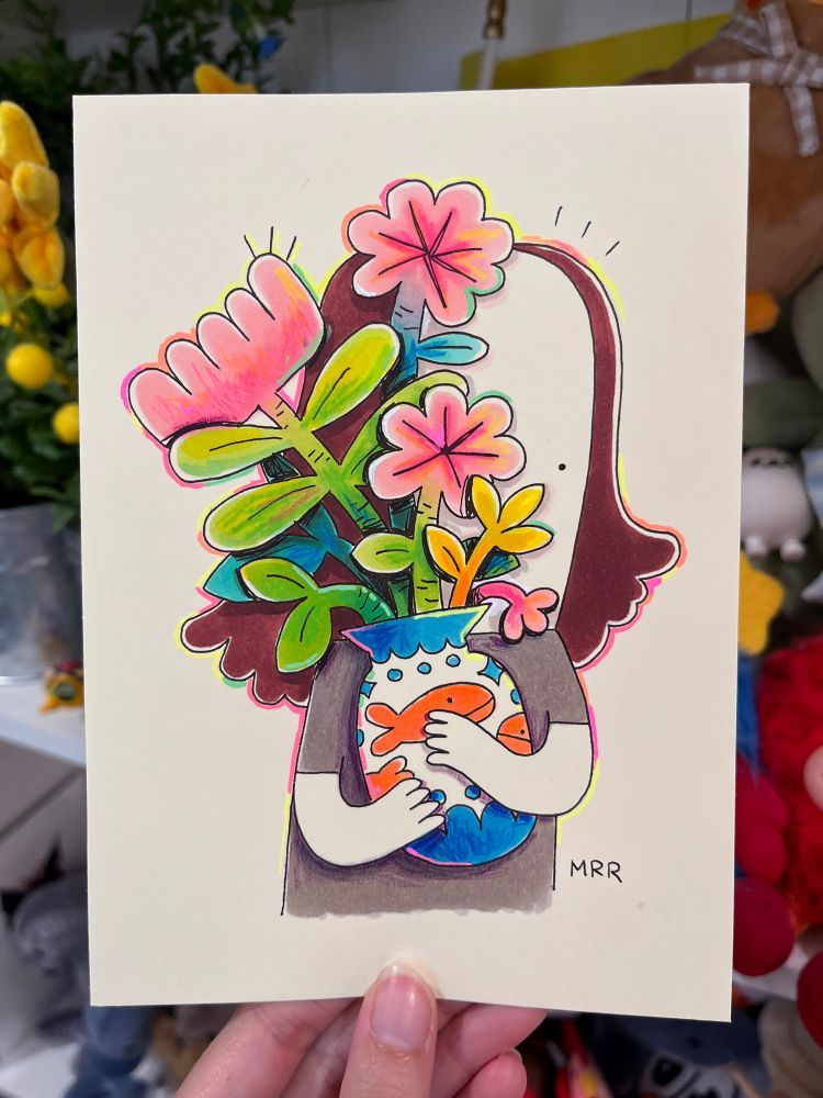 A hold holding up a traditional drawing of a cartoon character hugging a vase with flowers in it 
