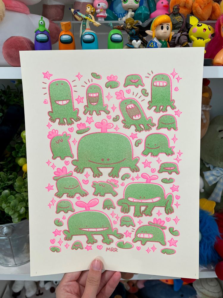 A Risograph print featuring so many frogs and lily pads! The frogs are smiling with teeth, doing kissy faces, sticking their tongues out, smiling, or grimacing. The lines are fluorescent pink and the frogs are Kelly green.