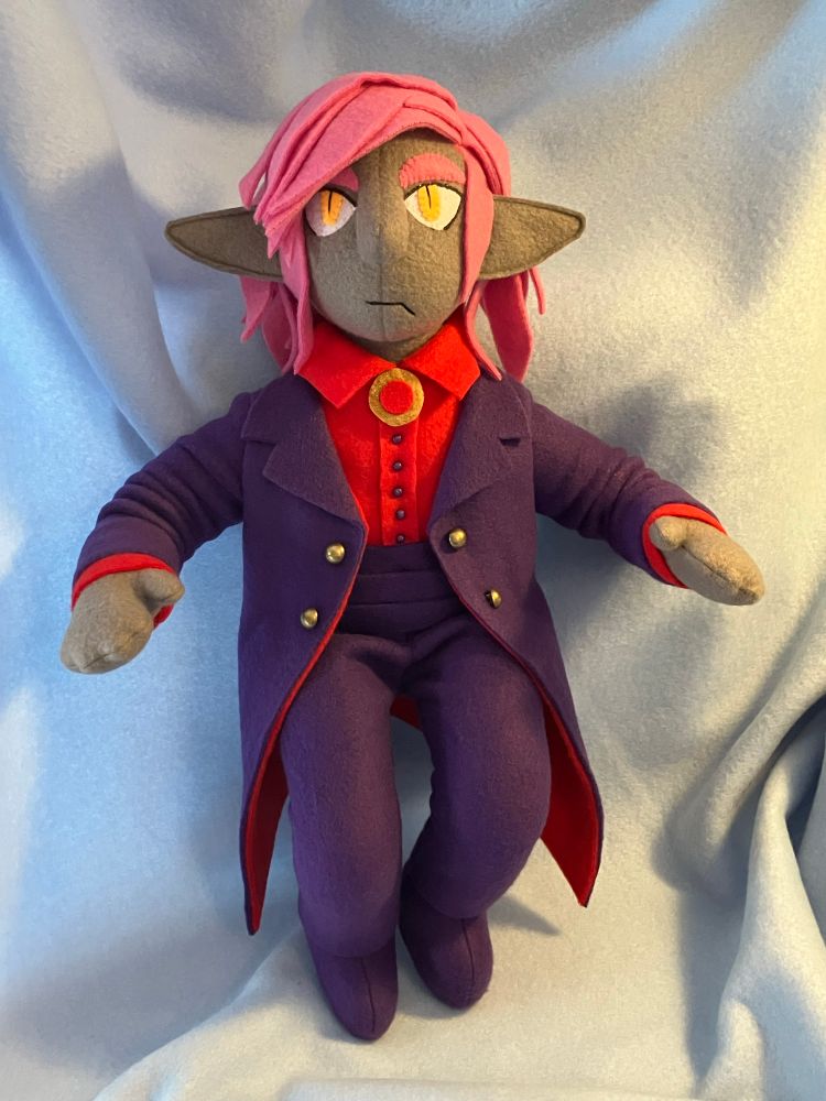 A hand made doll with pink hair