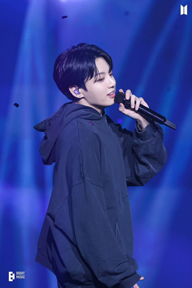 Jungkook of BTS, at his best, singing and looking happy.