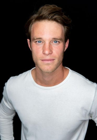 Josh Plasse standing against a black background.