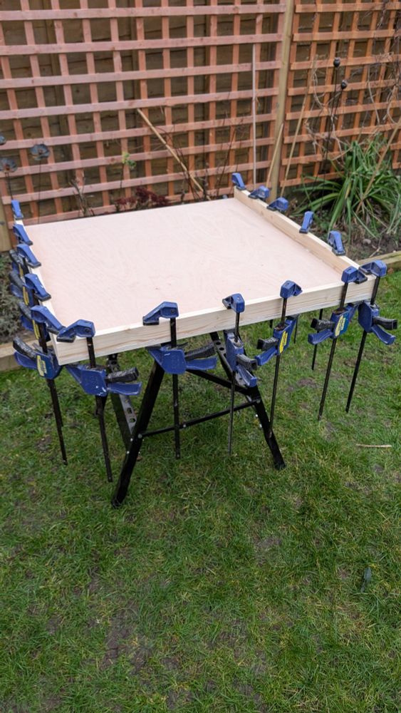 Wooden board being glued there is a lot of clamps 
