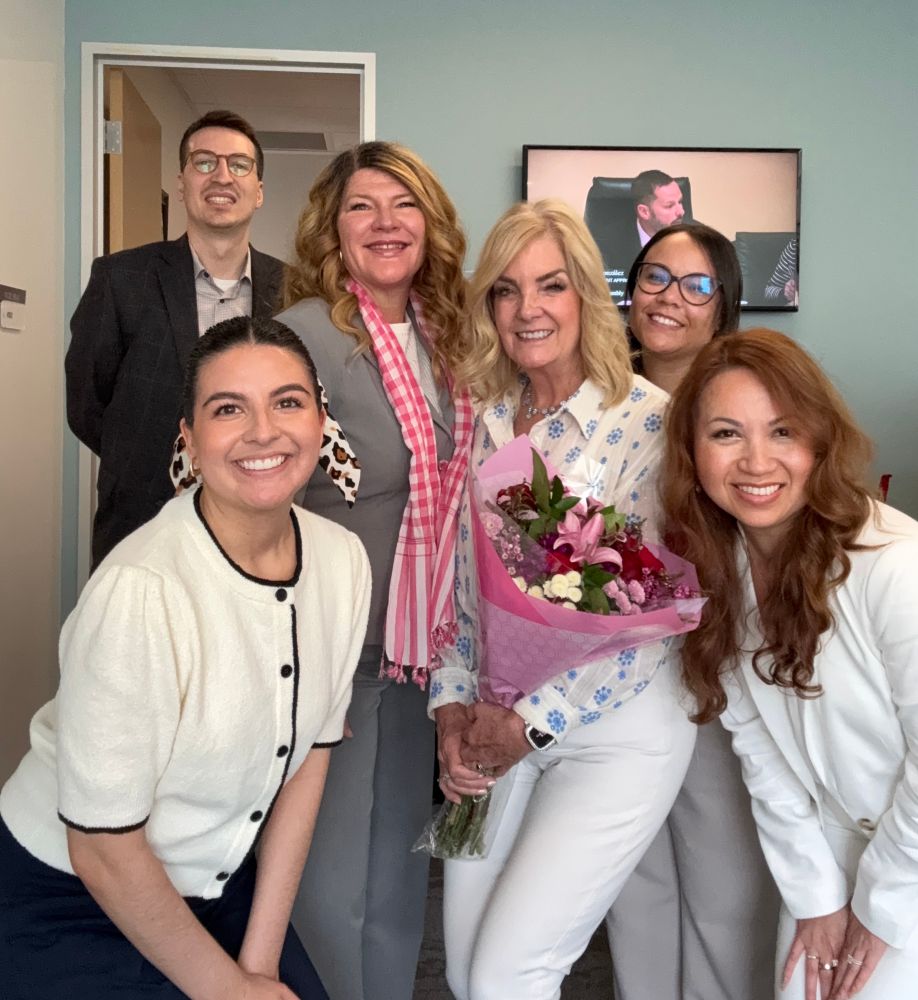 A picture of 5 women and a male from Assemblymember Boerner’s Office. At the center of the picture is Scheduler, Mary Cuevas, with flowers.