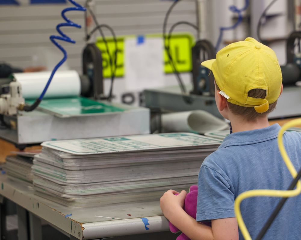 Child looks onto a sign being made