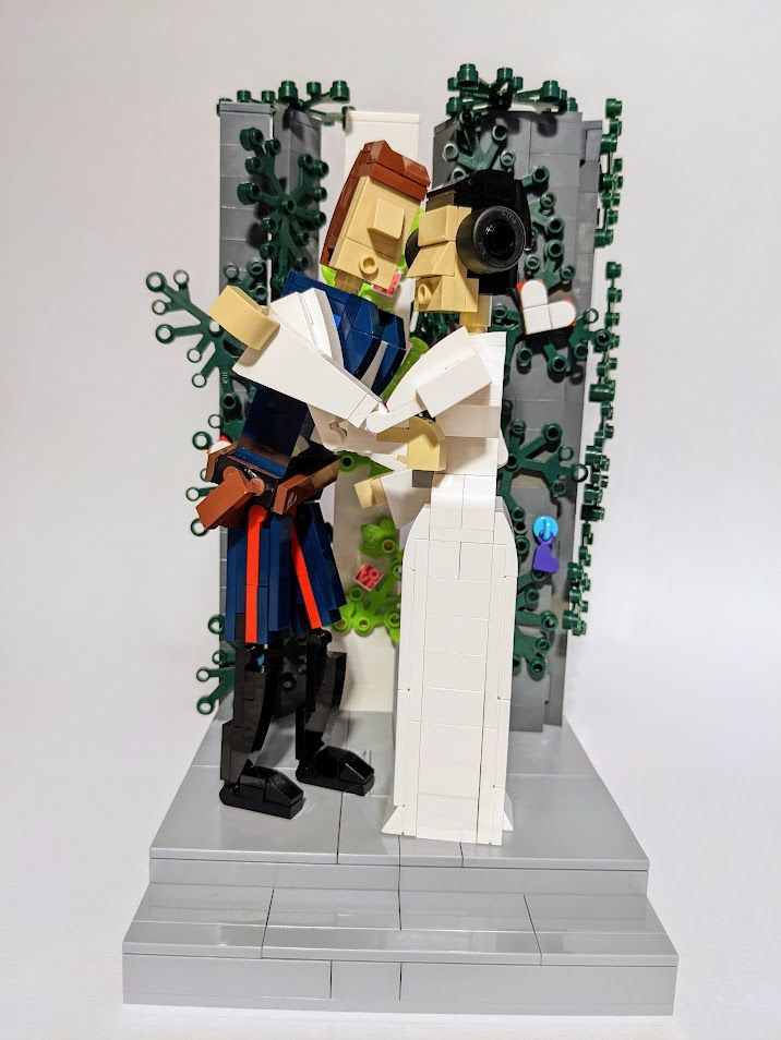 Star Wars characters Han and Leia kiss in front of gray columns covered with vines and hearts. The entire scene is built out of LEGO bricks.