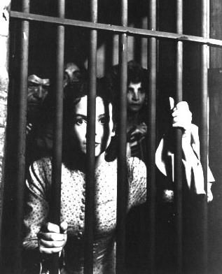 Nell Bowen, played by Anna Lee, looks out from behind bars in a scene from the film BEDLAM (1946).
