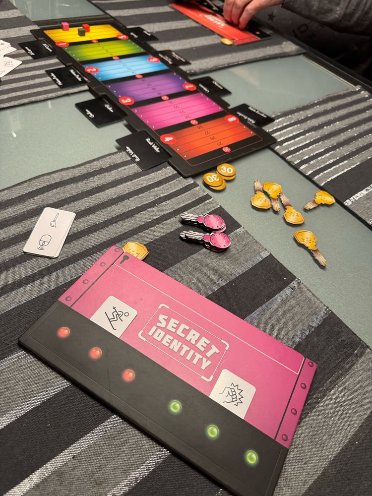 Das Spiel „Secret Identity“ liegt auf einem Tisch ausgebreitet.