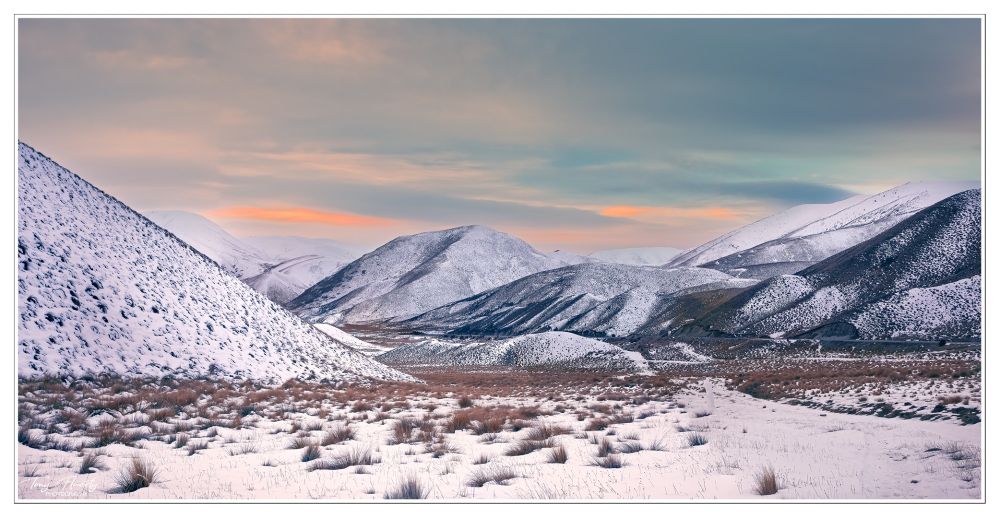 A snowy Lindis pass on a bleak day but with a hint of promise of a change coming. New Zealand. 