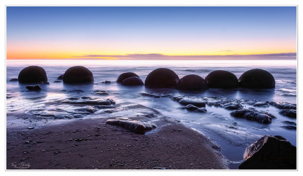 A winter sunrise at the Moeraki Boulders on the East Coast of the South Island in New Zealand.