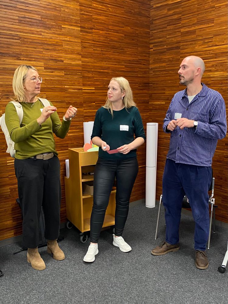 Drei Personen stehend im Gespräch