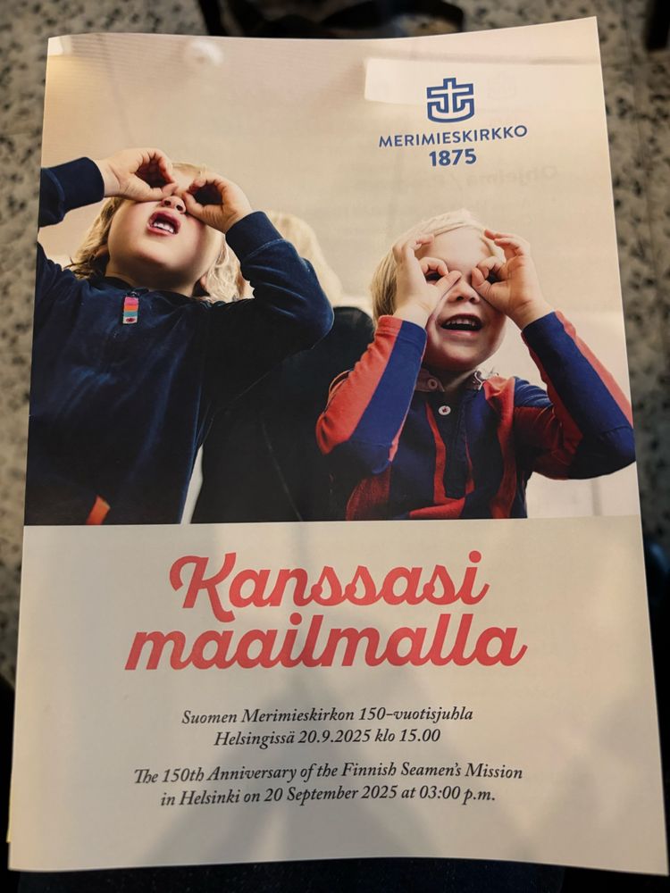 Zeigt zwei Kinder und den finnischen Text, der auf Deutsch heißt, zusammen in der Welt