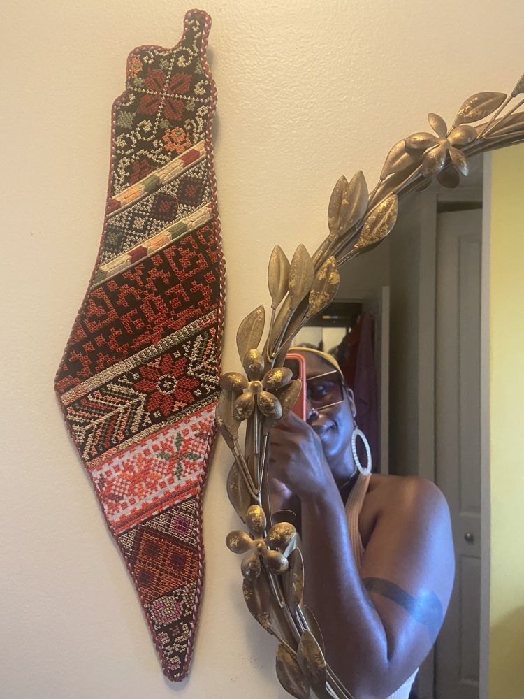 Photo of a Palestinian map decorated with traditional fabric designs.