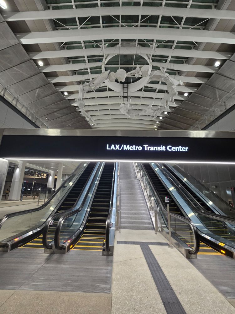 A bank of 4 escalators with a "LAX /Metro Transit Center sign above them