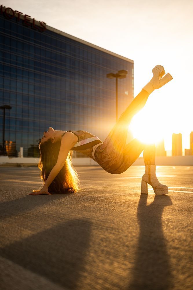 Goldie on parking garage at sunset, leg kicking in textured bodysuit