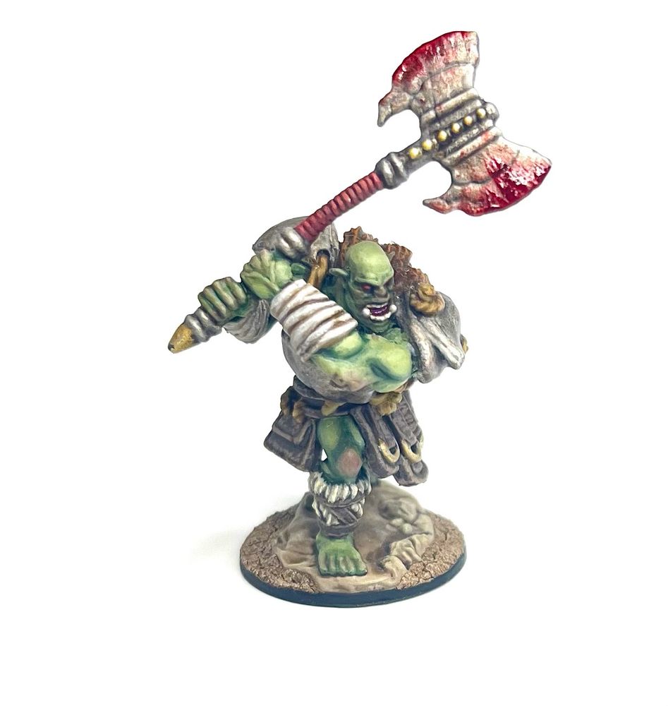 Another green orc, swinging a bloody axe with both hands. He has metal pauldrons and leather armour hanging from his waist. 