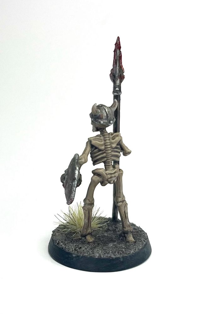 The spear-wielding skeleton miniature from the back, showing off their bony caboose.