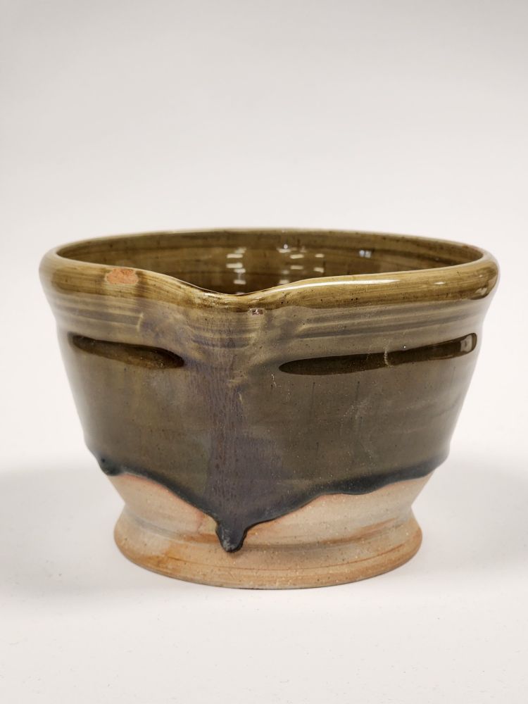 Front view of the first mixing bowl I've ever made. It has a brown glaze dripping down the sides